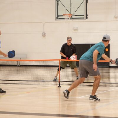humans playing pickleball on a court