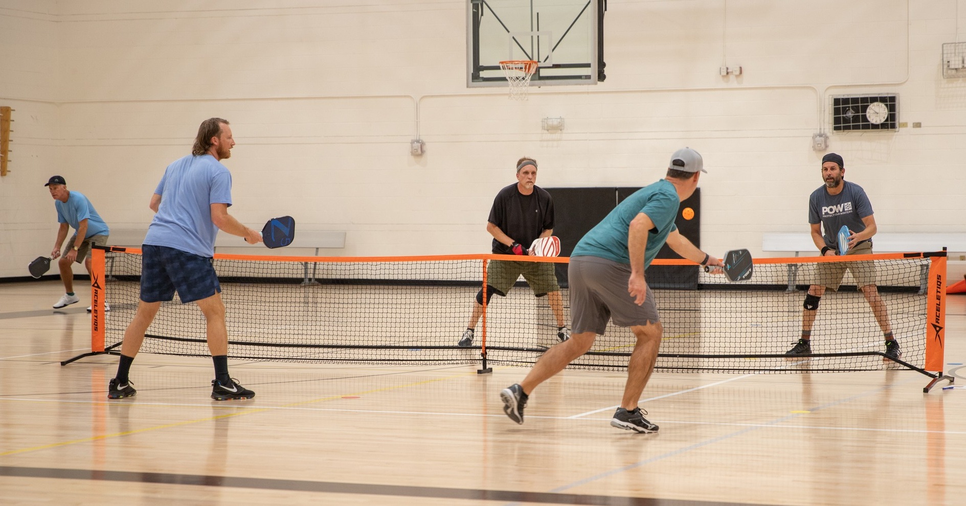 humans playing pickleball on a court